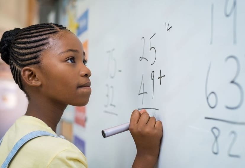 Leerling werkt een rekenopgave uit op het whiteboard