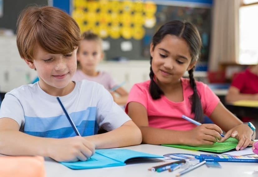 Twee leerlingen werken naast elkaar aan hun schrijfopdracht