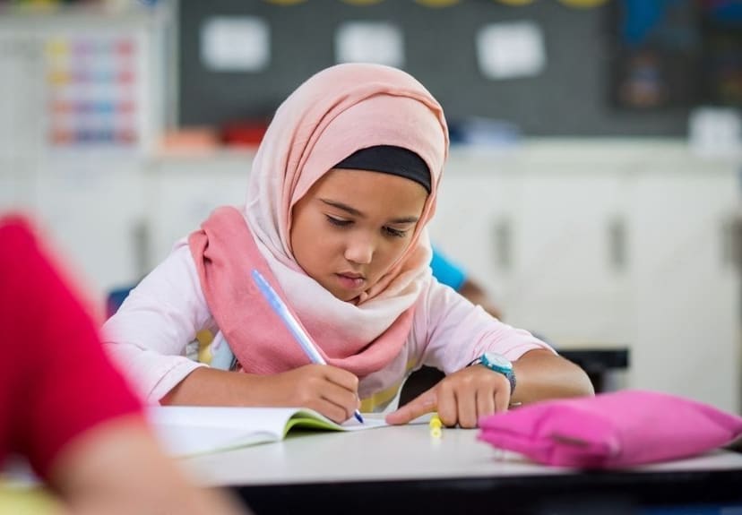 Leerling werkt geconcentreerd in haar schrift