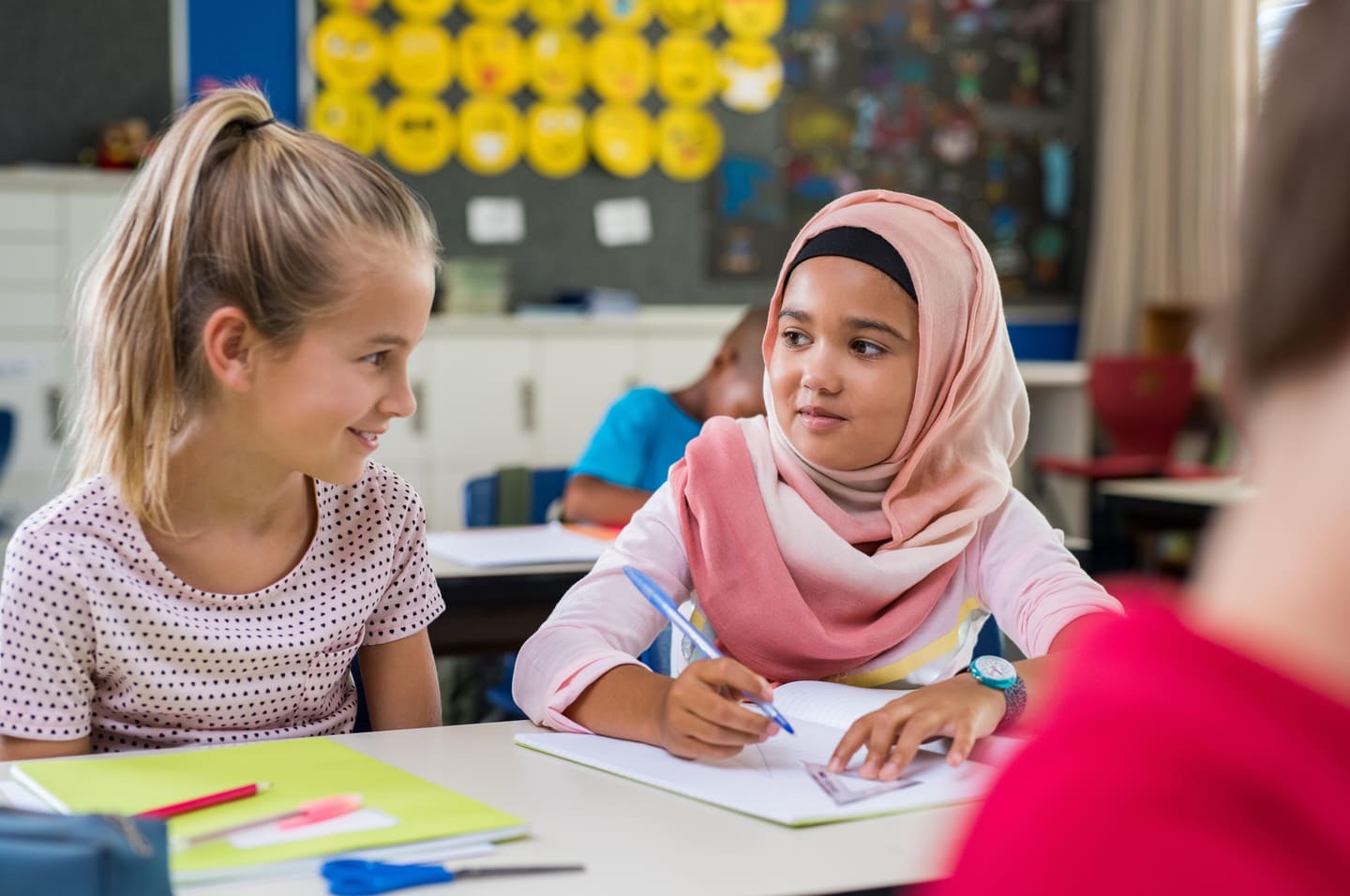 Twee leerlingen overleggen samen aan een tafel in de klas